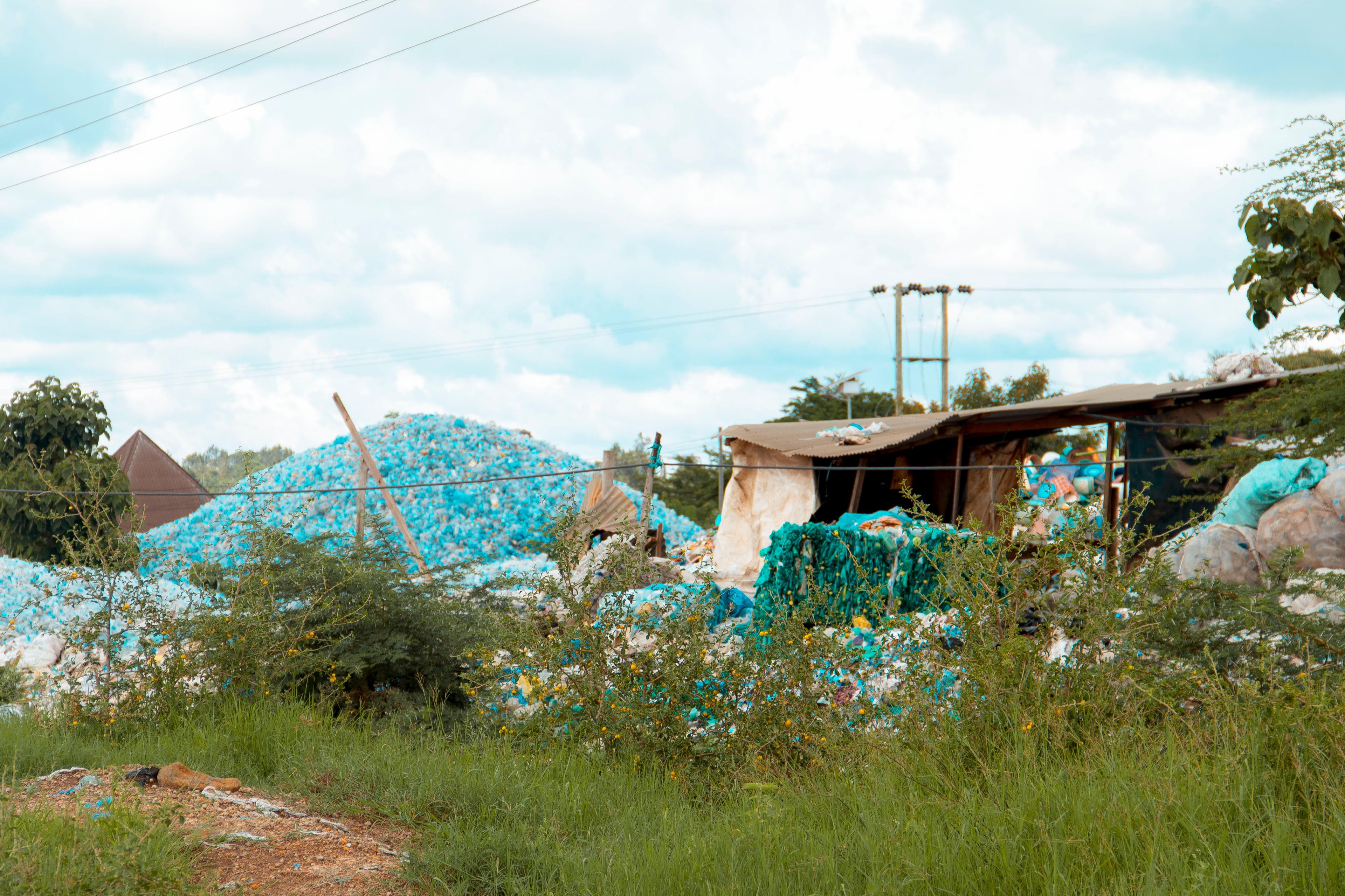 A wall of discarded plastic bottles at a landfill site.